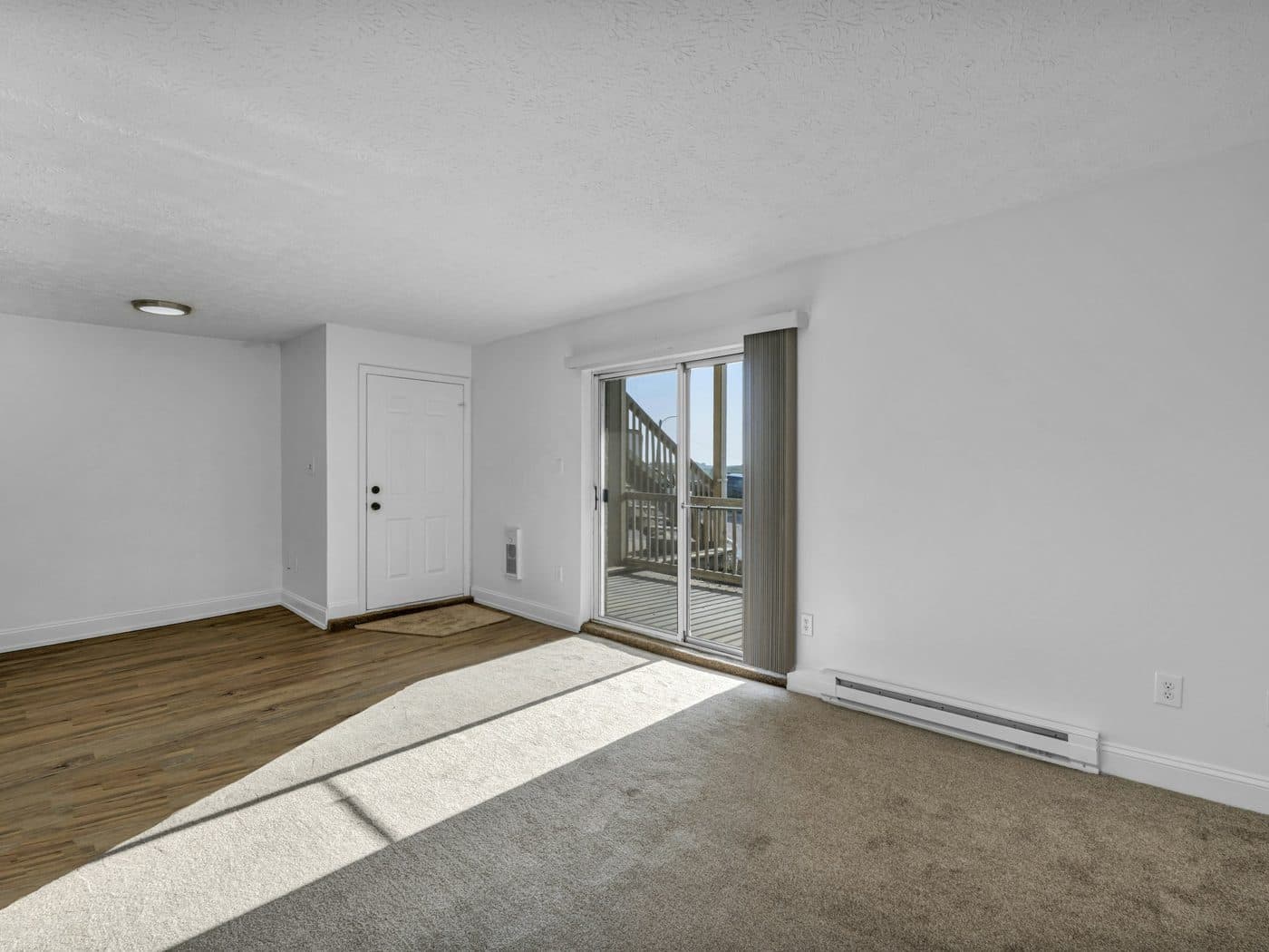 Pièce vide et claire, parquet et baie coulissante