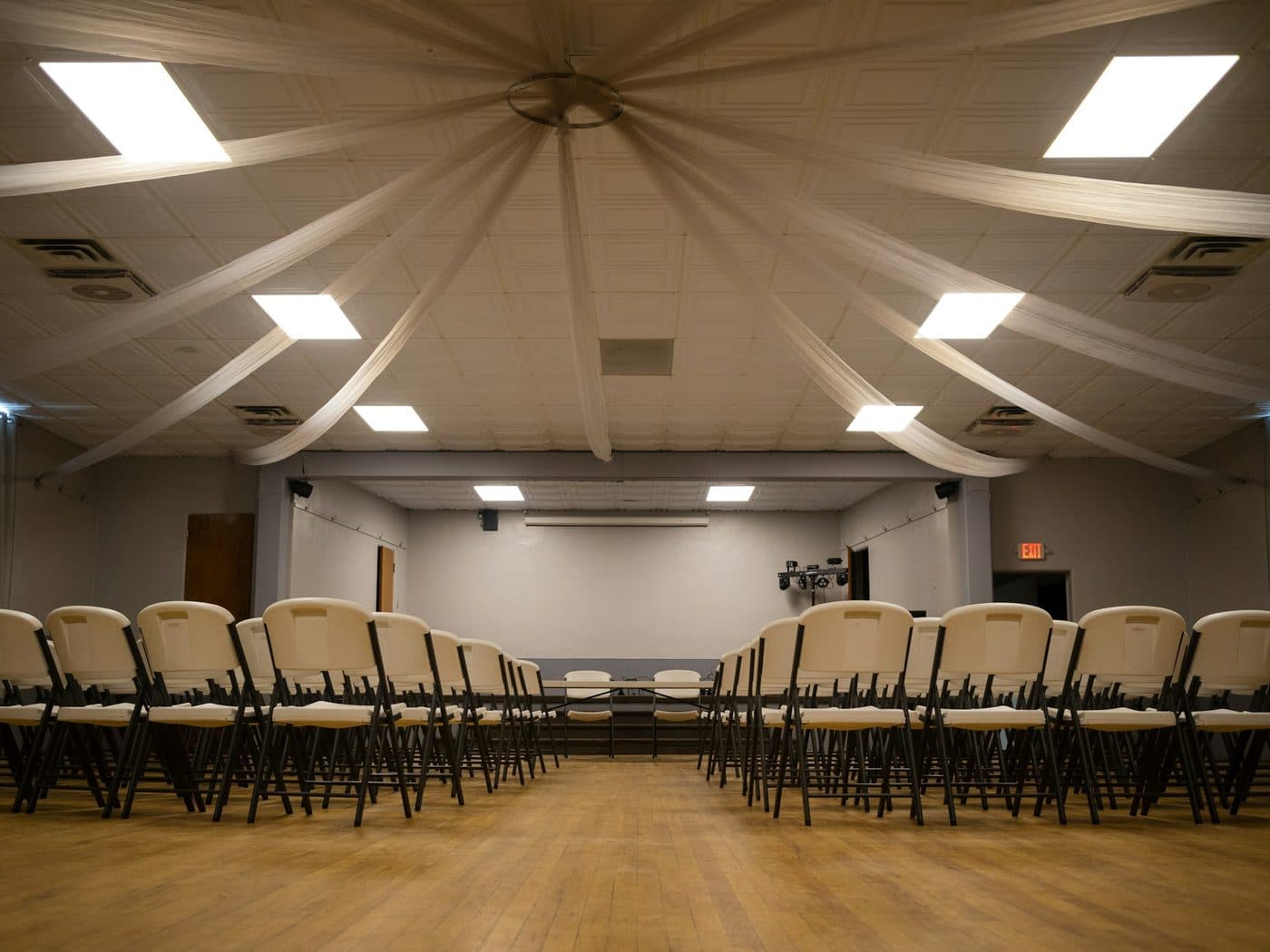Chaises blanches alignées dans une salle de réception vide